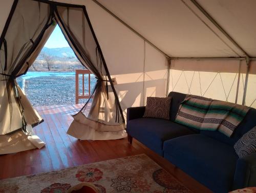 a living room with a couch in a tent at Cozy Glamp Tents at Wildland Gardens in Joseph