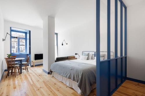 a bedroom with a bed and a table and chairs at Pensão Luisinha by Casas com Estória Boutique Houses in Santa Comba Dão