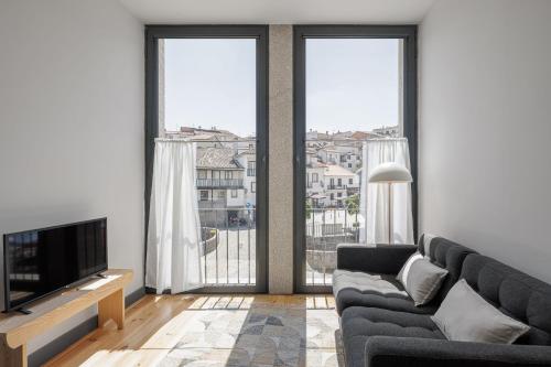 a living room with a couch and a television at Pensão Luisinha by Casas com Estória Boutique Houses in Santa Comba Dão