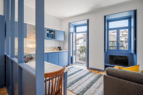 a kitchen with blue cabinets and a living room at Pensão Luisinha by Casas com Estória Boutique Houses in Santa Comba Dão