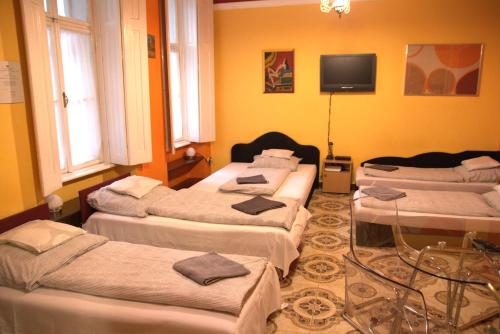 4 camas en una habitación con paredes amarillas en Astoria Centrum Studio Apartment, en Budapest