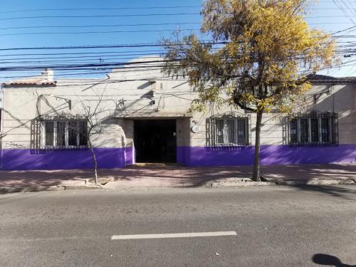 a purple building with a tree in front of it at Hostería Residencial Santa Rosa in Los Andes