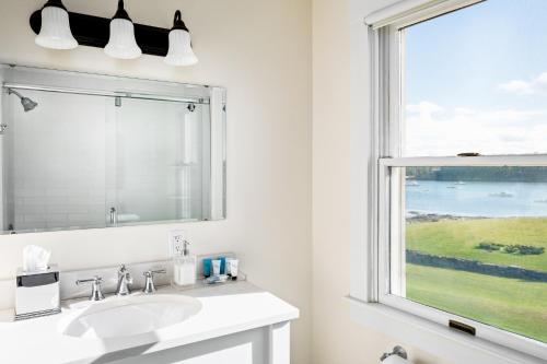 a bathroom with a sink and a window at East Wind Inn & Suites in Tenants Harbor