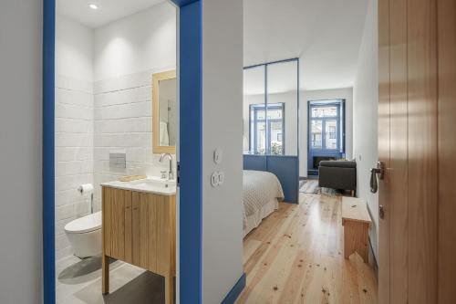 1 dormitorio con 1 cama y baño con lavabo. en Pensão Luisinha by Casas com Estória Boutique Houses en Santa Comba Dão