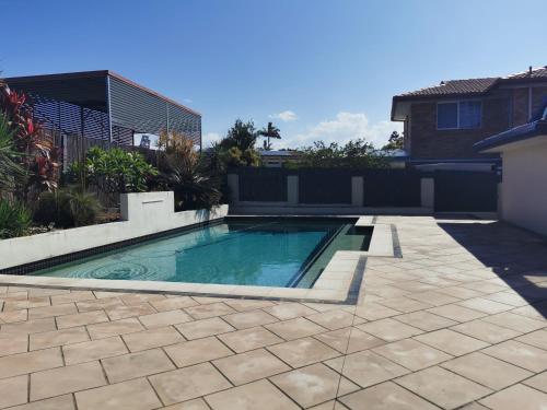 una piscina en un patio con una casa en Eight Mile Plains House en Brisbane