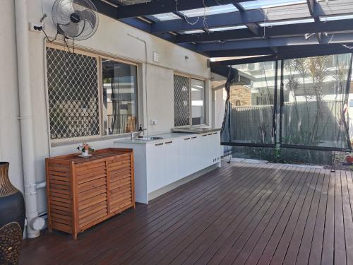 a bathroom with a sink and a wooden floor at Eight Mile Plains House in Brisbane