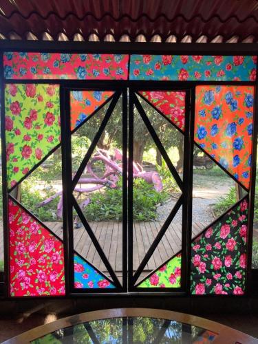 a stained glass window with a view of a garden at Planta Farm - Jungle Stay in Santa Maria Huatulco