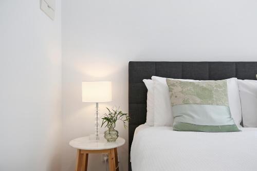 a bedroom with a bed with a lamp on a table at Timboon Tiny Homes in Timboon
