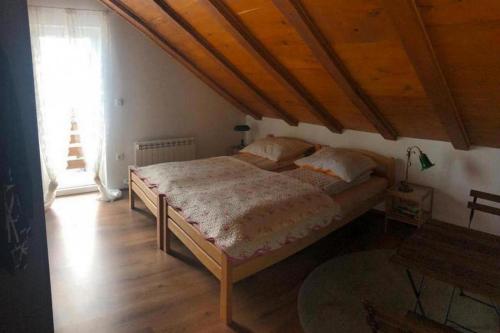 ein Schlafzimmer mit einem Bett mit Holzdecke in der Unterkunft Holiday house with a parking space Fuzine, Gorski kotar - 20330 in Fužine