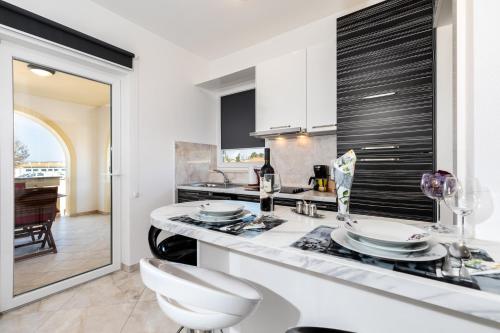 a kitchen with white cabinets and a white counter top at Apartments with parking space Punat, Krk - 20553 in Punat