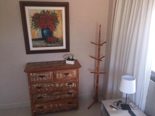 a room with a dresser with a painting on the wall at Apartamento no Complexo Iberostate in Acu da Torre