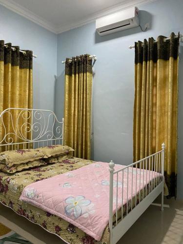 um quarto com uma cama com um cobertor rosa em dRose Homestay em Kuala Terengganu