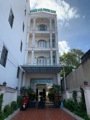 un edificio blanco alto con un letrero. en Phuong Dung Hotel en Buon Ma Thuot