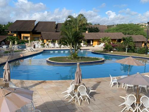 a large swimming pool with chairs and umbrellas at Winterville flat 307 in Gravatá
