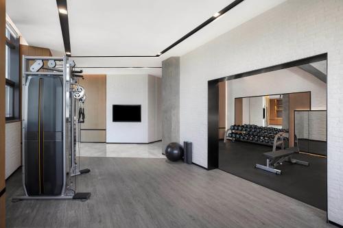 a large room with a gym with a large mirror at Four Points by Sheraton Shenzhen Bao'an in Shenzhen