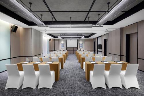a room with rows of tables and white chairs at Four Points by Sheraton Shenzhen Bao'an in Shenzhen