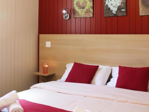 1 dormitorio con 1 cama con almohadas rojas y blancas en Res Le Parc des Vosges du Nord, Bitche, holiday home for 5 pers en Bitche