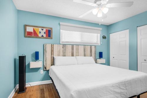 una camera con letto bianco e pareti blu di Crabby Lagoon C104 a Panama City Beach