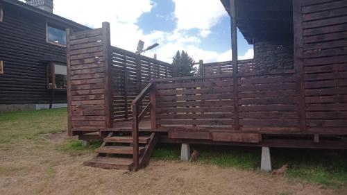 a wooden structure with a staircase in front of a house at PARCELA DE AGRADO CON PISCINA LAGO RANCO todas las instalaciones con uso exclusivo capacidad 20 personas in Lago Ranco