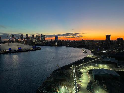 a view of a river with a city at sunset at ExcelLodge in London