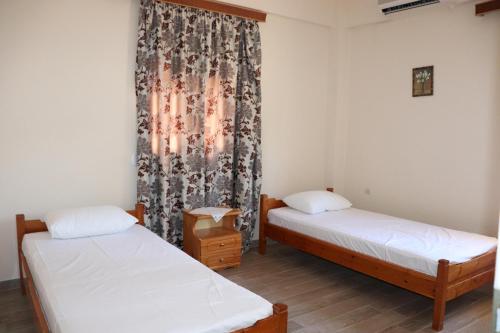 a room with two beds and a curtain at Anastassia EG in Koroni