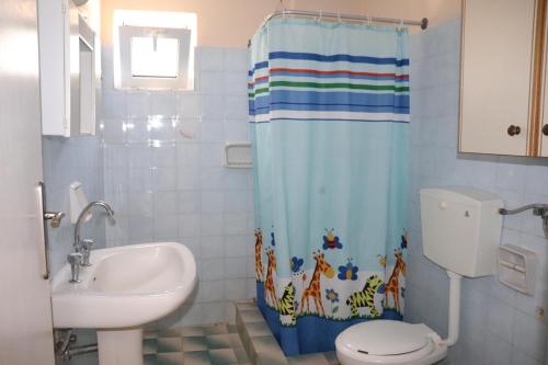 a bathroom with a sink and a toilet and a shower curtain at Anastassia EG in Koroni