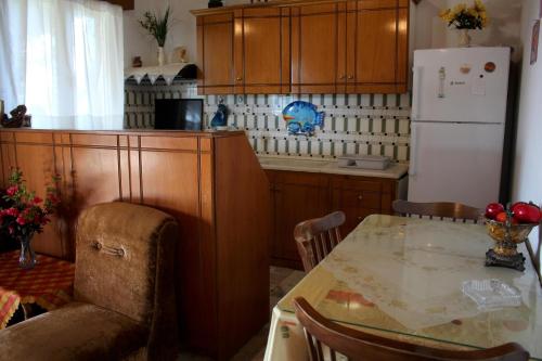 a kitchen with a table and a white refrigerator at Amalia in Áyios Ilías
