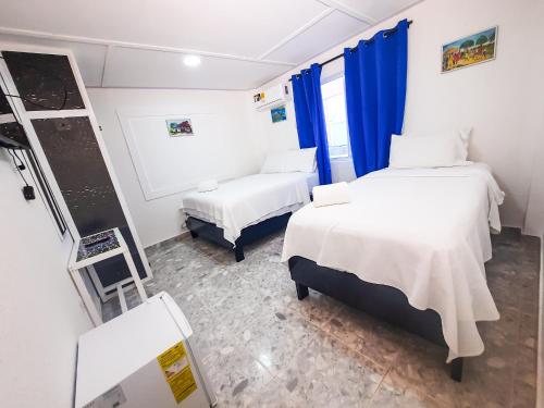 a hospital room with two beds and a chalkboard at Hotel Posada Enilda in Providencia