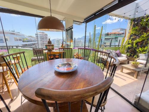 y balcón con mesa y sillas de madera. en Maravilhosa Cobertura com Vista Panorâmica, Piscina e varanda Gourmet B11-0012, en Río de Janeiro
