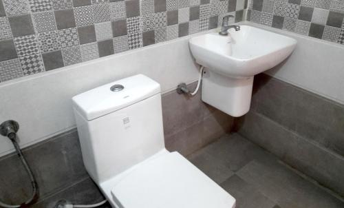 uma casa de banho com um WC e um lavatório em Louis Garden Homestay em Mararikulam