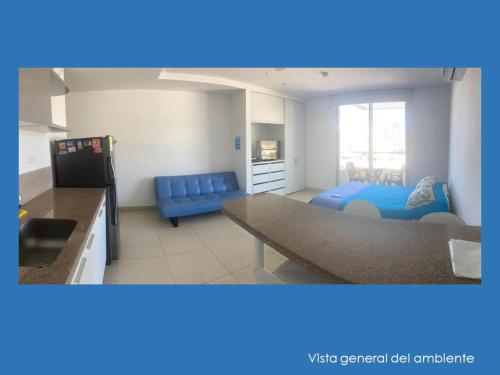 Una cocina y una sala de estar con un sofá azul. en Apartaestudio Velas al Mar Santa Marta, en Gaira