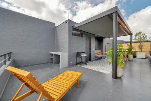 a patio with a bench and a table and a desk at Olive Living Suites by HOUSY HOST in Envigado