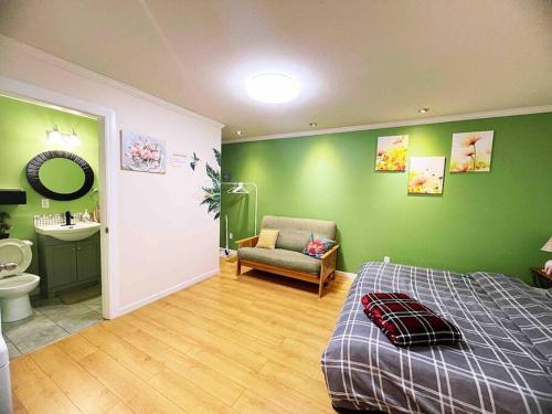 a bedroom with green walls and a bed and a bathroom at Separate access suite , separate kitchen, bathroom in Surrey