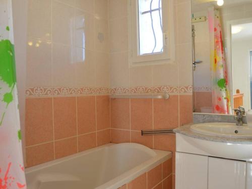 une salle de bain avec une baignoire et un lavabo dans l'établissement Villa 3 pièces climatisée avec parking et animaux acceptés à Saint-Pierre-la-Mer - FR-1-229D-614, à Saint Pierre La Mer