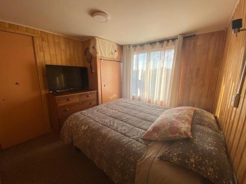 a bedroom with a bed and a flat screen tv at Hospedaje & Alojamientos Hilda in Puerto Montt