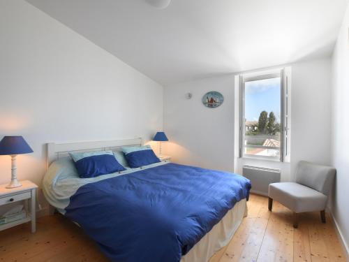 una camera da letto con un letto con lenzuola blu e una finestra di Maison Ars-en-Ré, 5 pièces, 9 personnes - FR-1-258-83 ad Ars-en-Ré