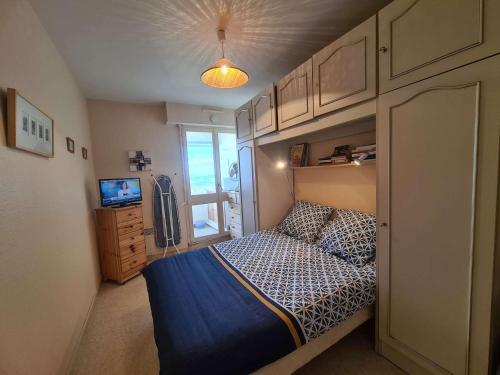 une petite chambre avec un lit et une télévision dans l'établissement Appartement 2 pièces avec balcon proche plage et commerces à Saint-Hilaire-de-Riez - FR-1-224C-21, à Saint-Hilaire-de-Riez