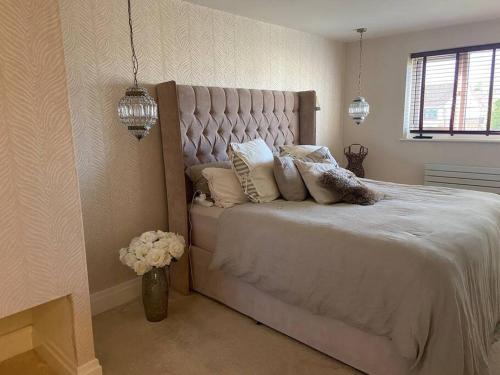 a bedroom with a large bed with pillows on it at Modern home in quiet neighbourly street, perfect for Work From Home, quick links to centre in Manchester