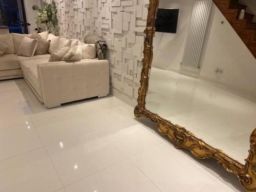 a living room with a mirror and a couch at Modern home in quiet neighbourly street, perfect for Work From Home, quick links to centre in Manchester
