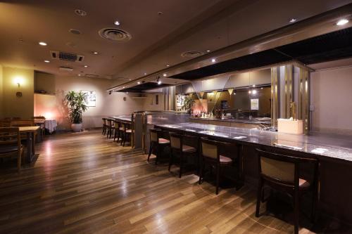 a bar in a restaurant with tables and chairs at Hotel Seiryu Japanese Spa inn with spectacular view in Osaka in Higashi-osaka