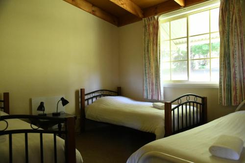 a bedroom with two twin beds and a window at Neerim Country Cottages in Neerim South