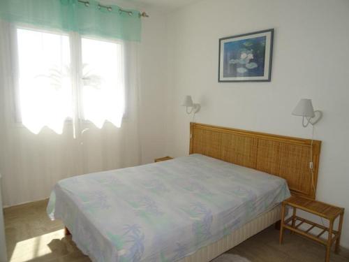 une chambre avec un lit, une chaise et une fenêtre dans l'établissement Appartement 1er étage avec parking, proche plage et commerces, Hyères - FR-1-335-165, à Hyères