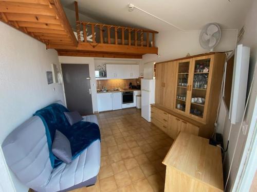 un salon avec un canapé et une cuisine dans l'établissement Appartement climatisé 2 pièces avec solarium pour 4 personnes, parking privé, proche plage - FR-1-335-166, à Hyères