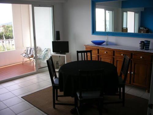 une cuisine avec une table et des chaises et une télévision dans l'établissement Appartement climatisé avec plage privée et parking à Hyères - FR-1-335-170, à Hyères