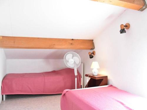 - une chambre avec un lit rose et un ventilateur dans l'établissement Charmant pavillon 6 couchages à 100m de la plage avec terrasse - Gruissan - FR-1-229-823, à Gruissan
