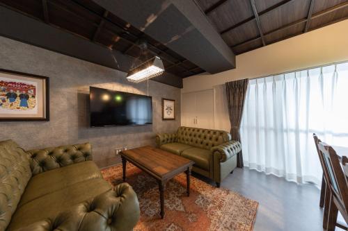 a living room with couches and a flat screen tv at trive osu kannon 駅チカ 大須商店街スグ 大須観音駅 徒歩30秒の好立地 in Minami-sotoborichō