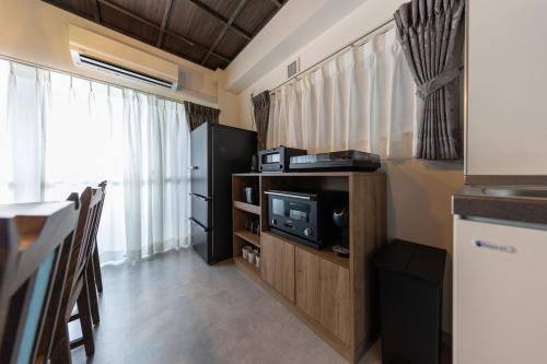 a room with a tv and a kitchen with a table at trive osu kannon 駅チカ 大須商店街スグ 大須観音駅 徒歩30秒の好立地 in Minami-sotoborichō