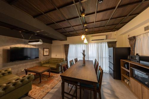 a living room with a dining room table and a couch at trive osu kannon 駅チカ 大須商店街スグ 大須観音駅 徒歩30秒の好立地 in Minami-sotoborichō