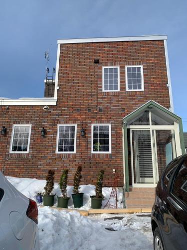 a brick house with potted plants in front of it at B&B HOTTA in Sapporo