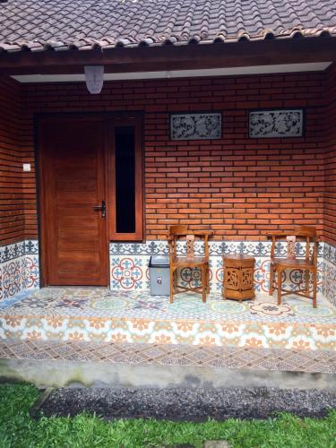 two benches sitting on the porch of a house at Raditya Homestay in Mambat